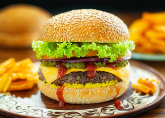 Fresh tasty burger on a plate with tomatoes and greens