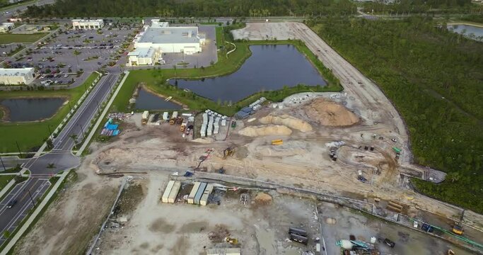 Development of residential housing in US suburbs. Beginning of construction works on prepared ground. Large building site with scattered equipment in american rural area. Real estate market in USA