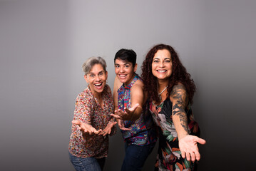 Three pretty female musicians wearing colorful clothes are confident and friendly.