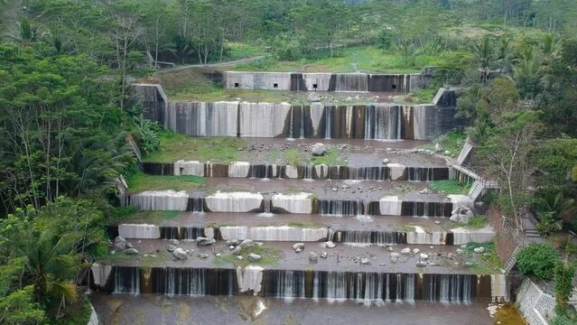 Aerial footage of the Watu Purbo sabo dam in Sleman, Indonesia which has a 6-level water dam. Apart from preventing the eruption of Mount Merapi, this dam is also a popular tourist destination