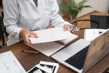 Heart Health Examination: In close-up detail, a cardiologist inspects patient ECG and ultrasound data, seated at a table with a computer. 