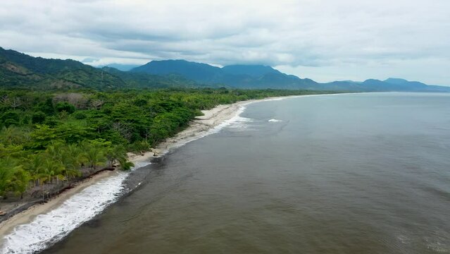 Captivating Drone Footage of Tropical Coastline Journey &ndash; Soaring Over Palm Trees and Rugged Mountains on the Left, Azure Sea Stretching to the Horizon on the Right
