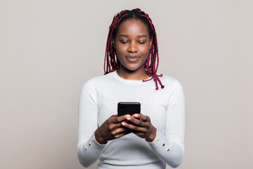 Dreamy attractive African American dark skinned woman with braids scrolling news online surfing Internet checking latest news all over the world