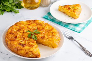 Spanish omelette with potatoes, typical spanish cuisine on gray concrete floor. Tortilla Espanola....