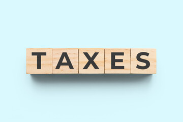 Taxes wooden cubes on light blue background