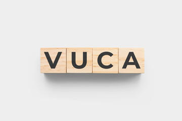 VUCA (Volatility, Uncertainty, Complexity, Ambiguity) wooden cubes on grey background
