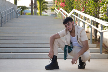 Latino and Hispanic boy, young and nonconformist, rebellious, with beige jacket and pants,...