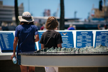 A Mother and Daughter at the Pearl Harbor Memorial Center looking at a Memorial Display about the Missing Ships at Pearl Harbor