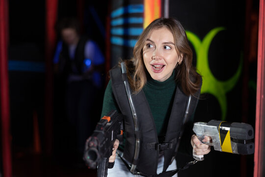 Young woman playing lasertag in arena