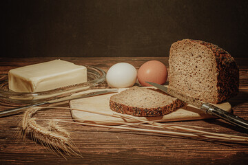 Still life with natural products: alcohol, eggs, bread and butter, stylized as antique - 649947706