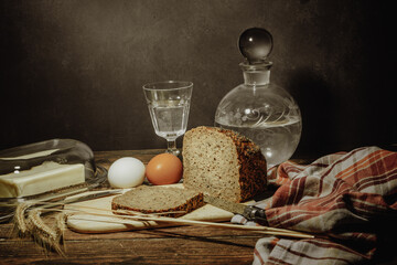 Still life with natural products: alcohol, eggs, bread and butter, stylized as antique - 649947708