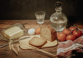 Still life with natural products: alcohol, eggs, bread and butter, stylized as antique - 649947710