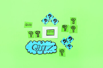 Word QUIZ in speech bubble with question marks and card on green background