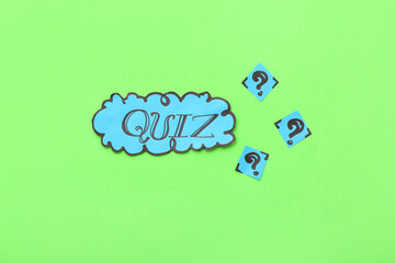 Word QUIZ in speech bubble with question marks on green background