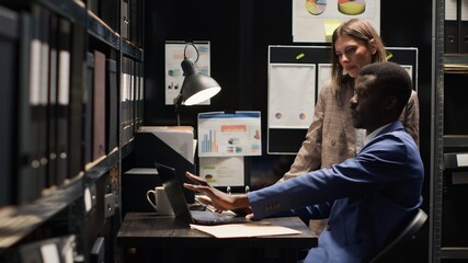 African american and caucasian police officers conduct detailed investigation and analyzes evidence...