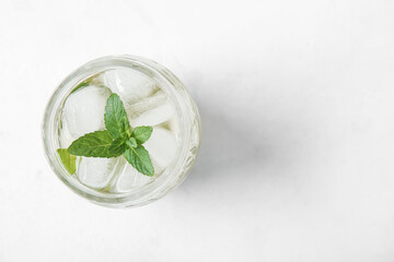 Glass of fresh icy mint tea on white background