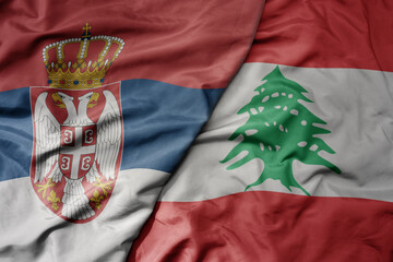 big waving national colorful flag of serbia and national flag of lebanon .