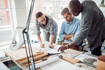 Diverse group of architects working on a project together in a modern company office