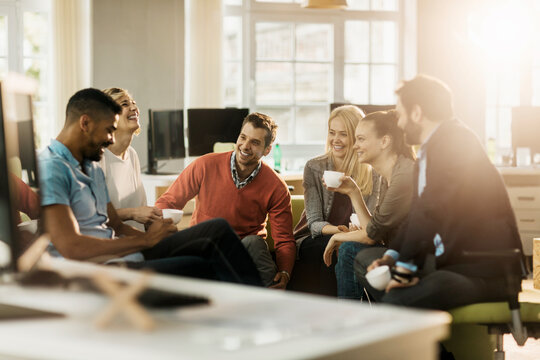 Young and diverse group of people having coffee and relaxing after work in the marketing company office