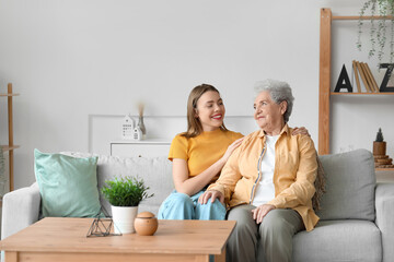 Young woman with her grandmother sitting on sofa at home