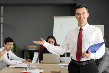 Male business consultant with clipboard working in office
