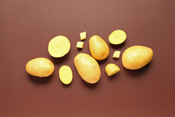 Raw potatoes on brown background