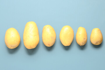 Raw potatoes on blue background