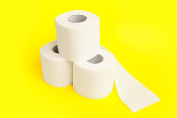 Rolls of toilet paper on yellow background