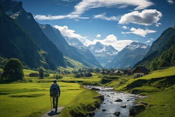a man walking on a path in a valley with mountains in the background - Powered by Adobe