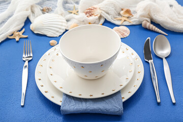 Beautiful table setting with marine decor on blue background