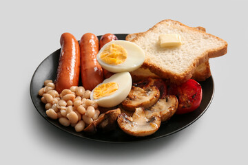 Plate of tasty English breakfast with boiled egg on grey background