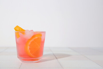 Glass of tasty Negroni cocktail on light tile table
