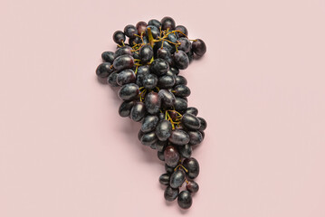 Sweet black grapes on lilac background