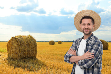 Confident farmer with crossed arms in field. Harvesting season