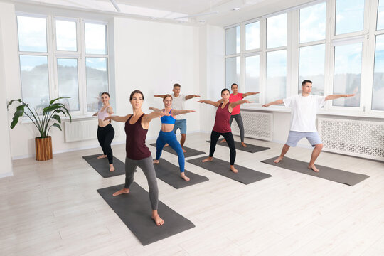 Group of people practicing yoga on mats indoors