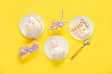 Plates with pieces of yummy Birthday cake and gift boxes on yellow background
