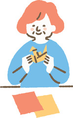 施設で折り紙を折る高齢者の女性_色