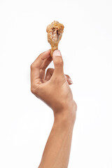 A human hand holding a grilled chicken wing