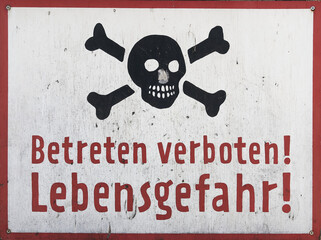 Handgemaltes Schild auf einem alten Firmengelände mit der Aufschrift Betreten verboten Lebensgefahr