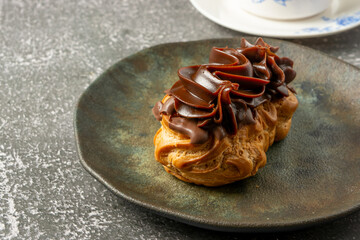 bomba de chocolate or eclair is a brazilian bakery shop sweet food dessert, over marble table