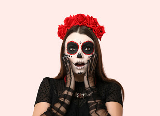 Surprised young woman dressed for Halloween on light background, closeup