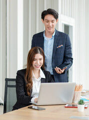 Asian female intern businesswoman in formal suit sitting smiling typing laptop notebook computer...