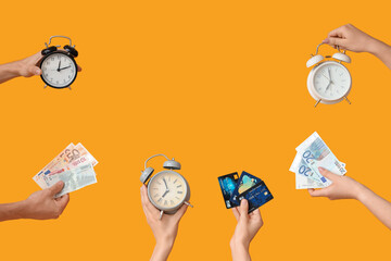 Hands holding different alarm clocks, money and credit cards on yellow background
