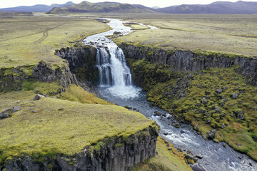 Aerial view of waterfall and volcanic plains in Fjallabak Nature Reserve, Iceland on sunny autumn day.