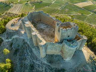 Aerial view of Davalillo castle above the Ebro river in Rioja Spain, with semicircular towers and tower of homage medieval defensive residential building, blue cloudy sky background © tamas
