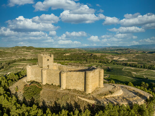 Aerial view of Davalillo castle above the Ebro river in Rioja Spain, with semicircular towers and tower of homage medieval defensive residential building, blue cloudy sky background © tamas