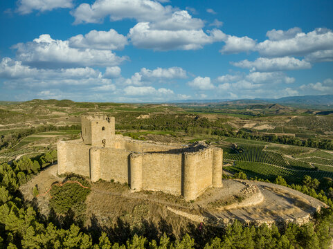 Aerial view of Davalillo castle above the Ebro river in Rioja Spain, with semicircular towers and tower of homage medieval defensive residential building, blue cloudy sky background