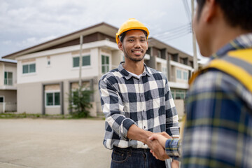 Obraz premium Architect and engineer shaking hands at job site, the project commissioned by the client, and the custom design before delivery. Interior design and decoration ideas.