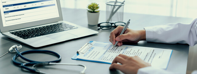 Doctor carefully review detailed medical report on laptop and diagnosing illness for effective...