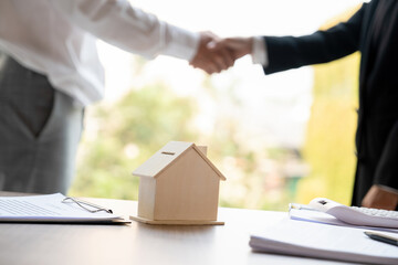 Real estate agent and buyer shaking hands on agreement.
